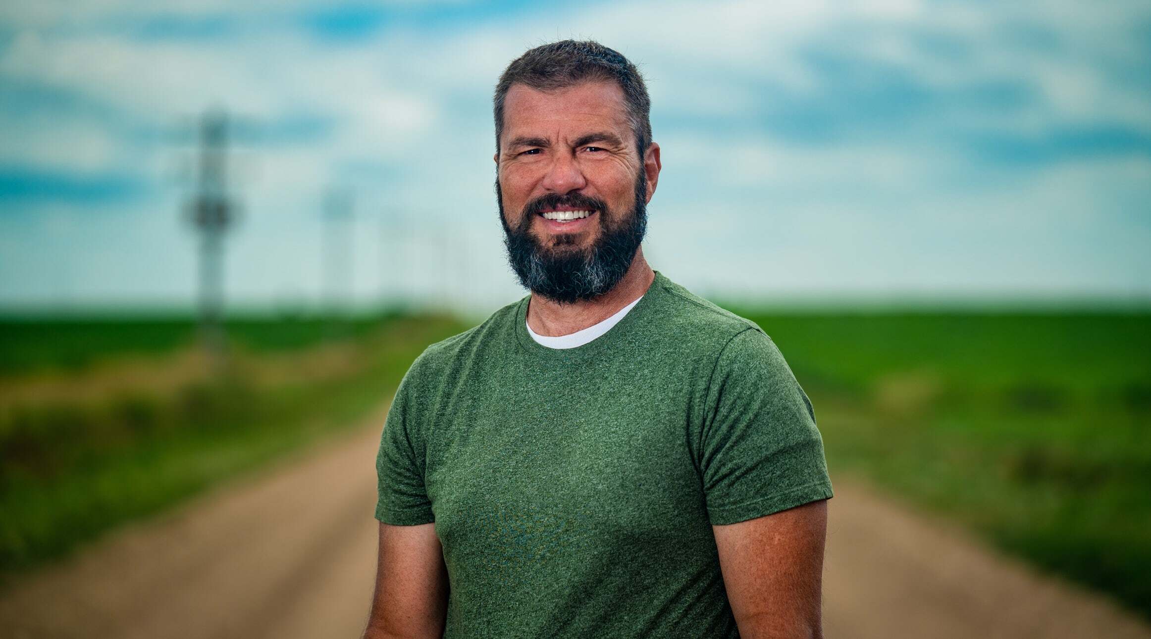 Multi-generational corn farmer Brandon Hunnicutt stands in his corn field.